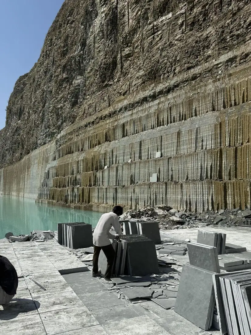 The Shekhar Stone quarry at Ramganj Mandi, with cut stone walls, stacked Kota stone slabs and water in the pit