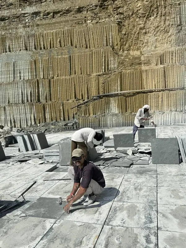 Workers dressing Kota stone slabs by hand on the quarry floor