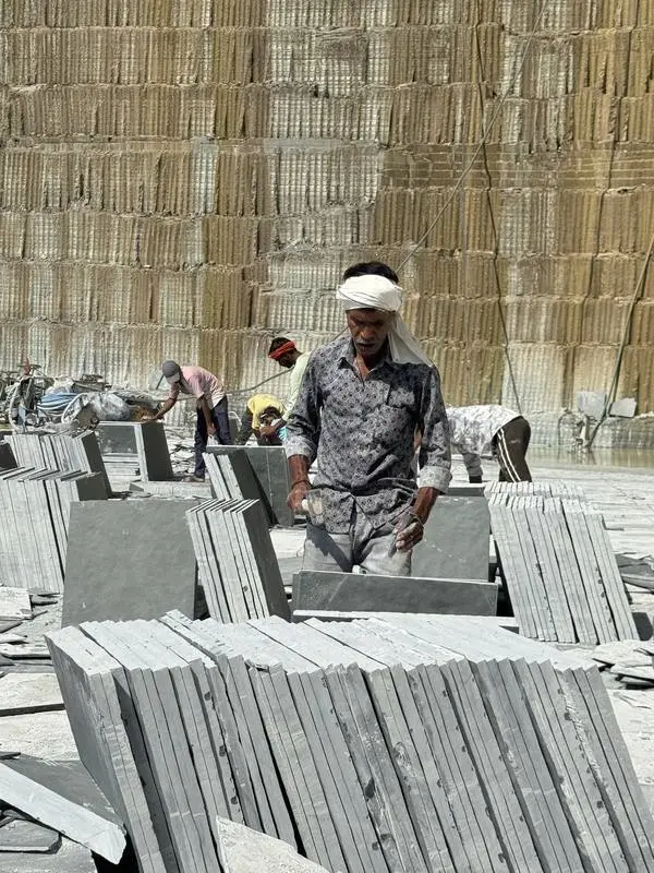 A worker stacking finished Kota stone slabs